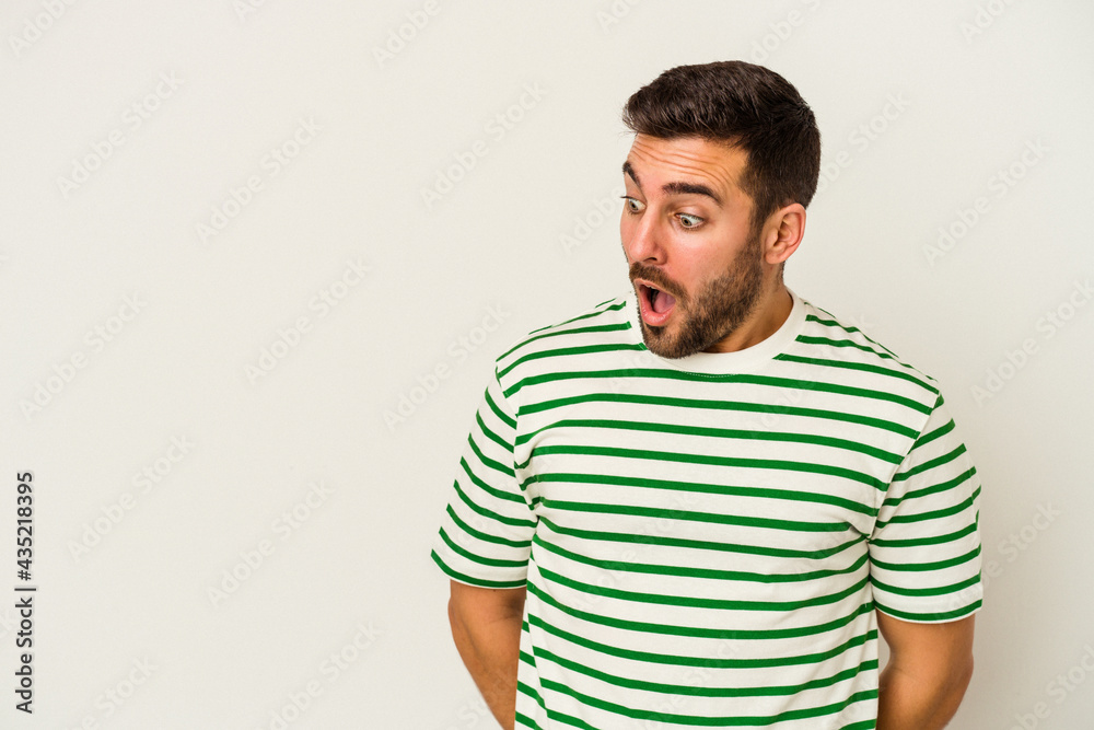 Young caucasian man isolated on white background being shocked because of something she has seen. Young caucasian man isolated on white background being shocked because of something she has seen.