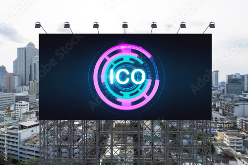 ICO hologram icon on billboard over panorama city view of Bangkok at day time. The hub of blockchain projects in Southeast Asia. The concept of initial coin offering, decentralized finance