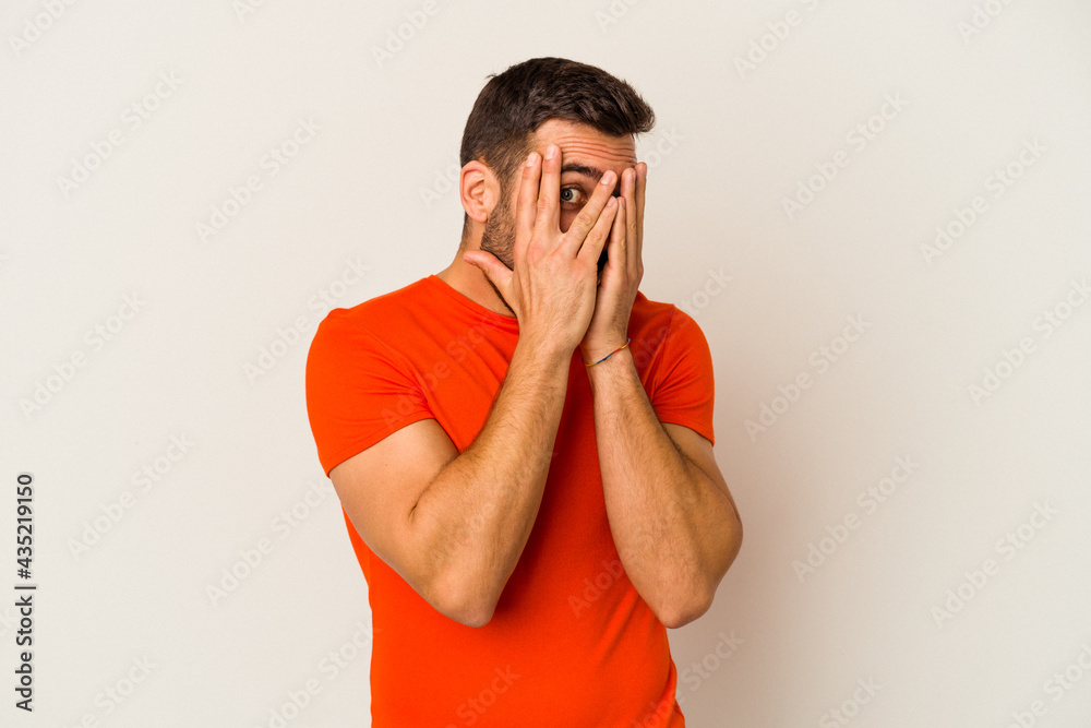 Young caucasian man isolated on white background blink through fingers frightened and nervous. Young caucasian man isolated on white background blink through fingers frightened and nervous.