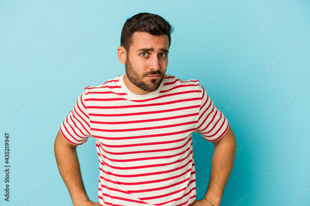 Young caucasian man isolated on blue background confused, feels doubtful and unsure. Young caucasian man isolated on blue background confused, feels doubtful and unsure.