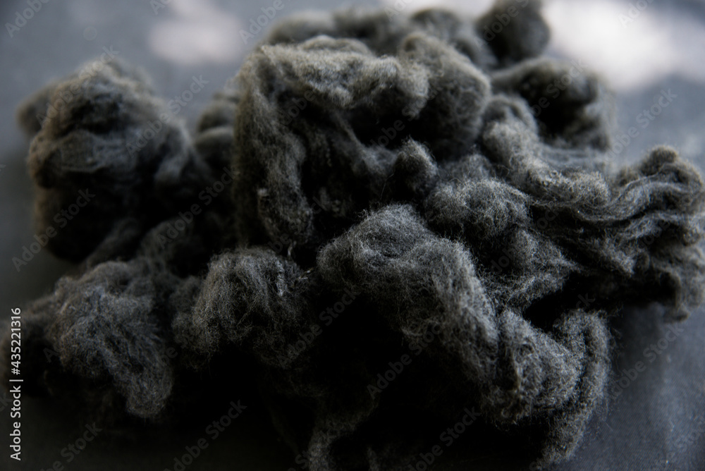 Black Polyester stable fiber with blurred green background Black Polyester stable fiber with blurred green background