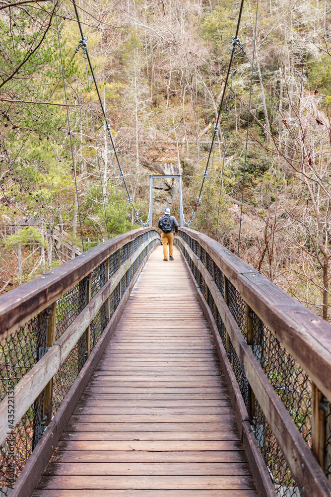 Mountaineer walking on a wooden suspension bridge