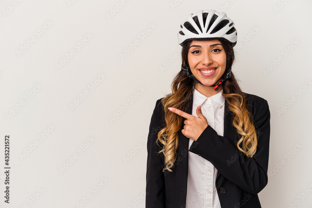 Young mexican woman riding a bicycle to work isolated on white background smiling and pointing aside, showing something at blank space. Young mexican woman riding a bicycle to work isolated on white background smiling and pointing aside, showing something at blank space.