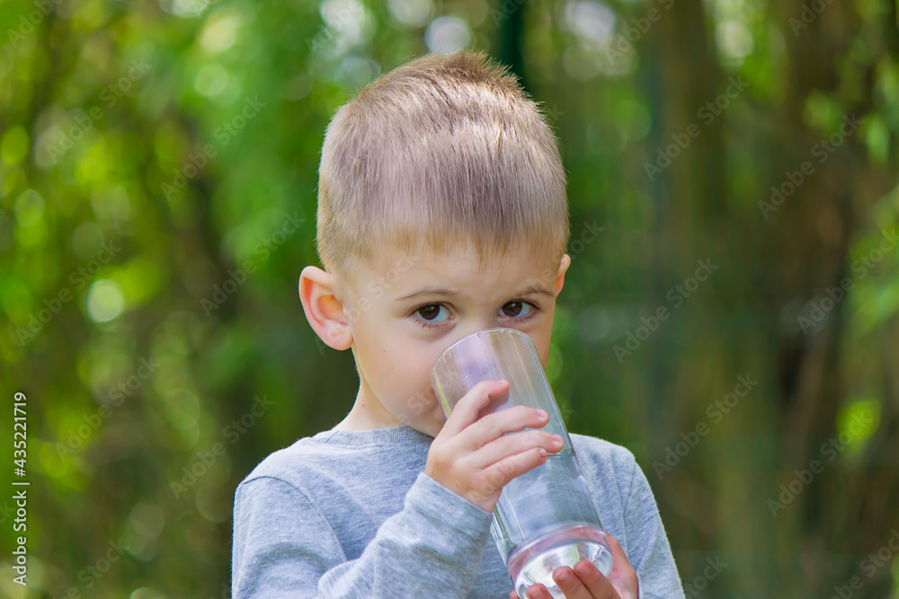 The child drinks clean water in summer. Selective focus. The child drinks clean water in summer. Selective focus.