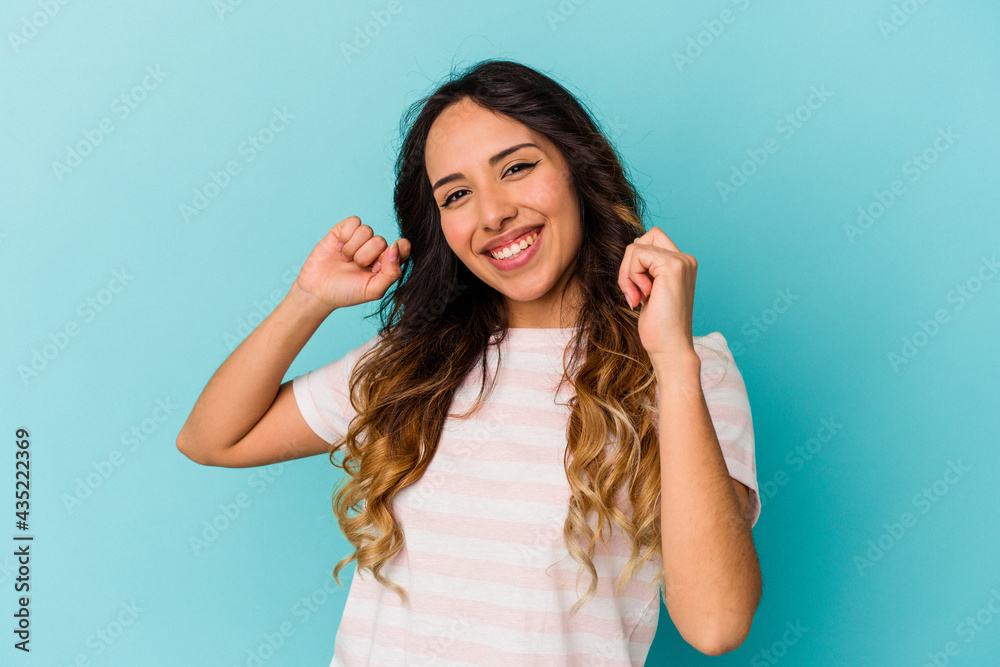 Young mexican woman isolated on blue background dancing and having fun. Young mexican woman isolated on blue background dancing and having fun.