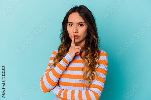 Young mexican woman isolated on blue background unhappy looking in camera with sarcastic expression. © Asier
