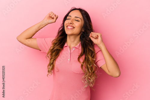 Young mexican woman isolated on pink background celebrating a special day, jumps and raise arms with energy.