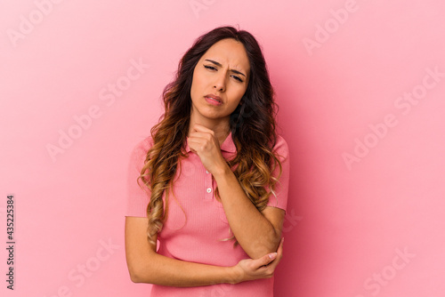 Young mexican woman isolated on pink background massaging elbow, suffering after a bad movement.