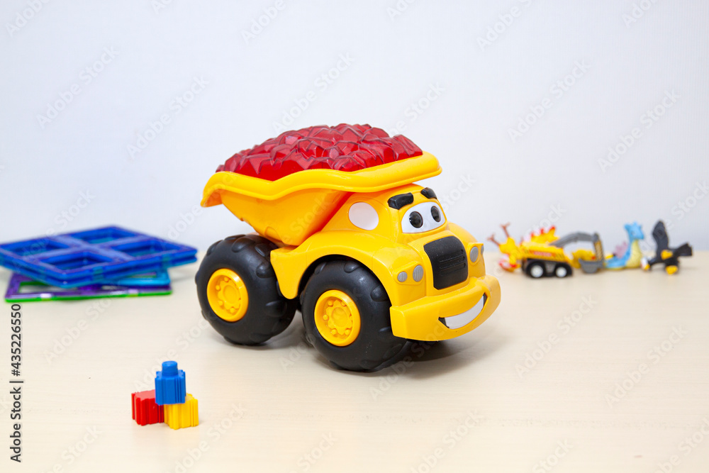 The yellow dump truck toy on the table. The yellow dump truck toy on the table.
