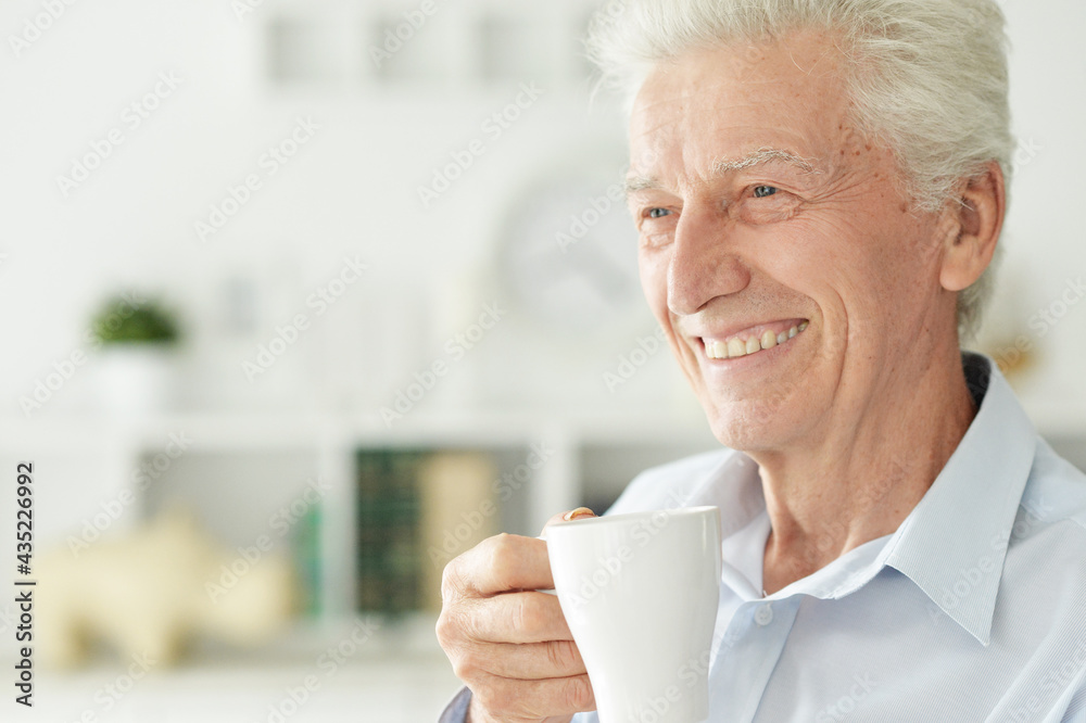 Portrait of smiling senior man drinking coffee at home Portrait of smiling senior man drinking coffee at home