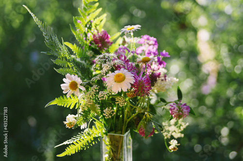 Close-up of a summer field bouquet against a blurred green background.