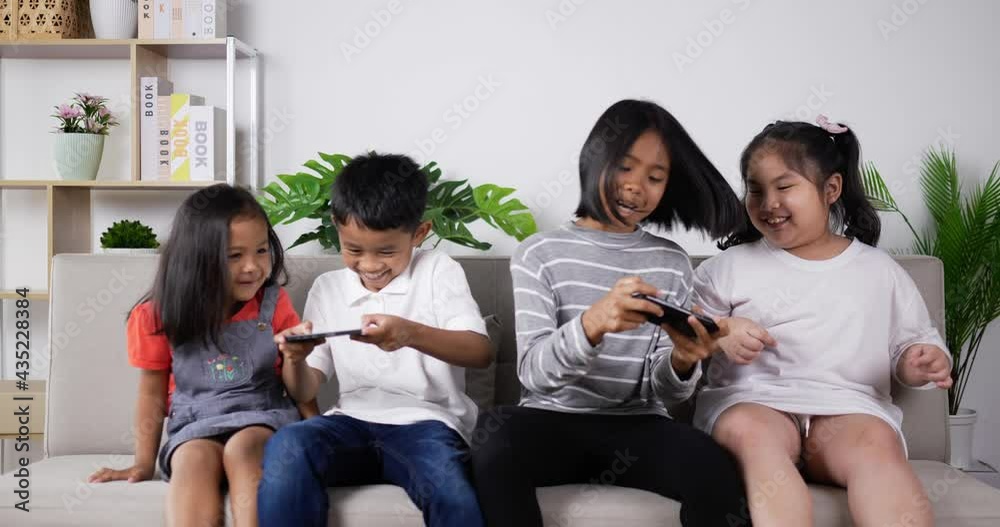 Children play mobile phones And tease around on sofa Children play mobile phones And tease around on sofa