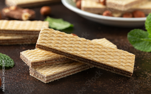 Tasty wafer biscuits with chocolate on rustic table photo