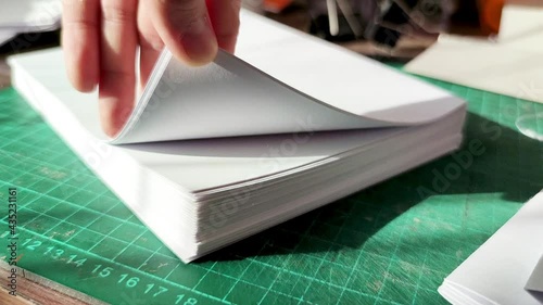 Office paper. Female hand close up flips through sheets of office paper. Crafting a Handmade Notebook
