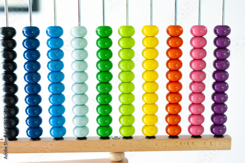 Obraz na płótnie Multi-colored designer background. Calculating Colorful wooden rainbow abacus for number calculation. Close up wooden abacus on white background. Mathematics learning concept. Rainbow colors w salonie