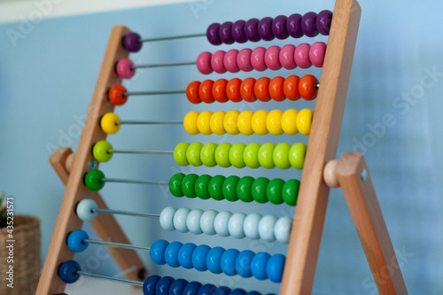 Obraz na płótnie Multi-colored designer background. Calculating Colorful wooden rainbow abacus for number calculation. Close up wooden abacus on white background. Mathematics learning concept. Rainbow colors w salonie