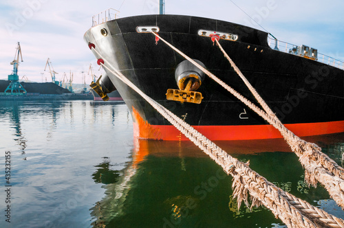 The bow of an industrial ship at the mooring wall in the seaport