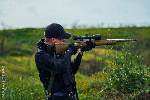 Police sniper aiming at the scope of his rifle