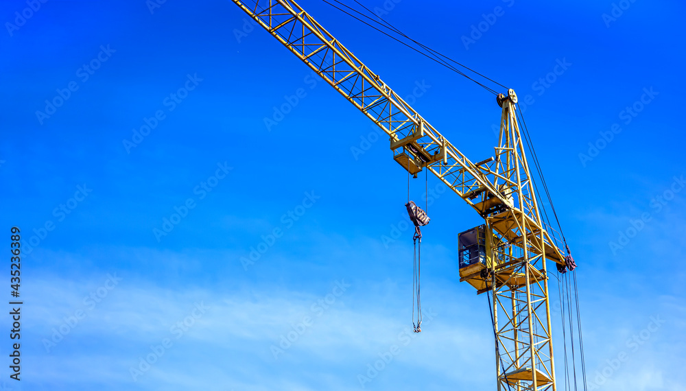 Lifting crane. Construction of a new multi-storey brick house.