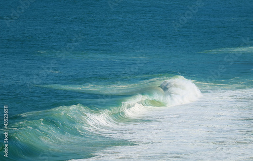 Aerial View of Powerful Waves Splashing on the Vibrant Blue Sea 