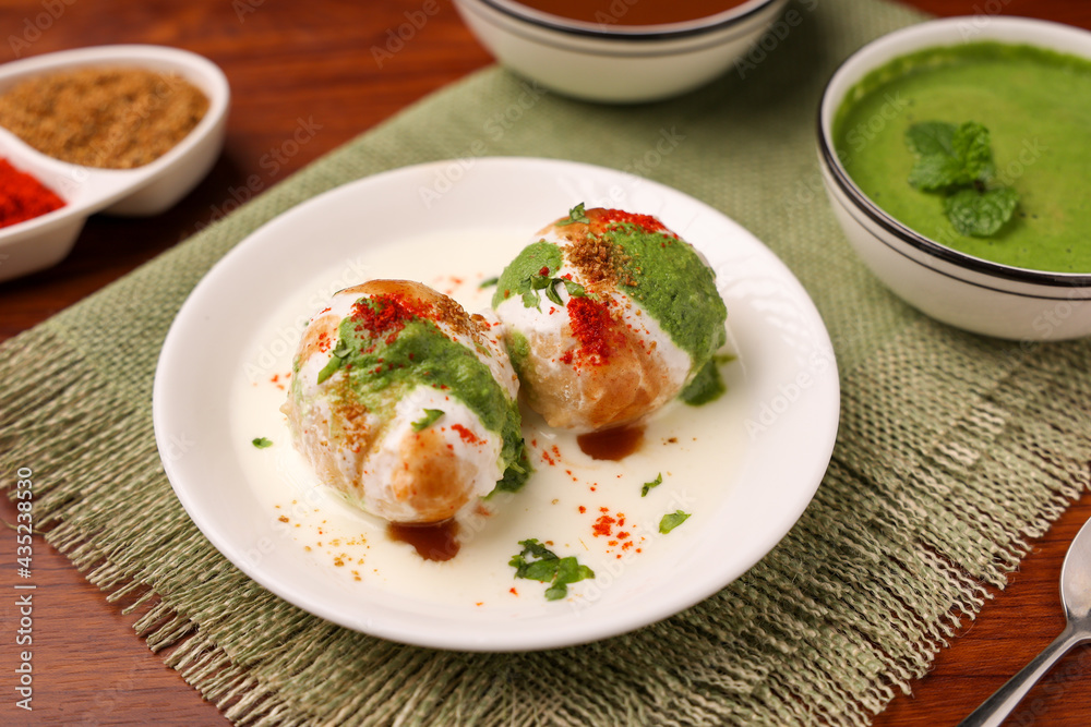 Indian street food Dahi vada Dahi Bhalla with green chutney, tamarind