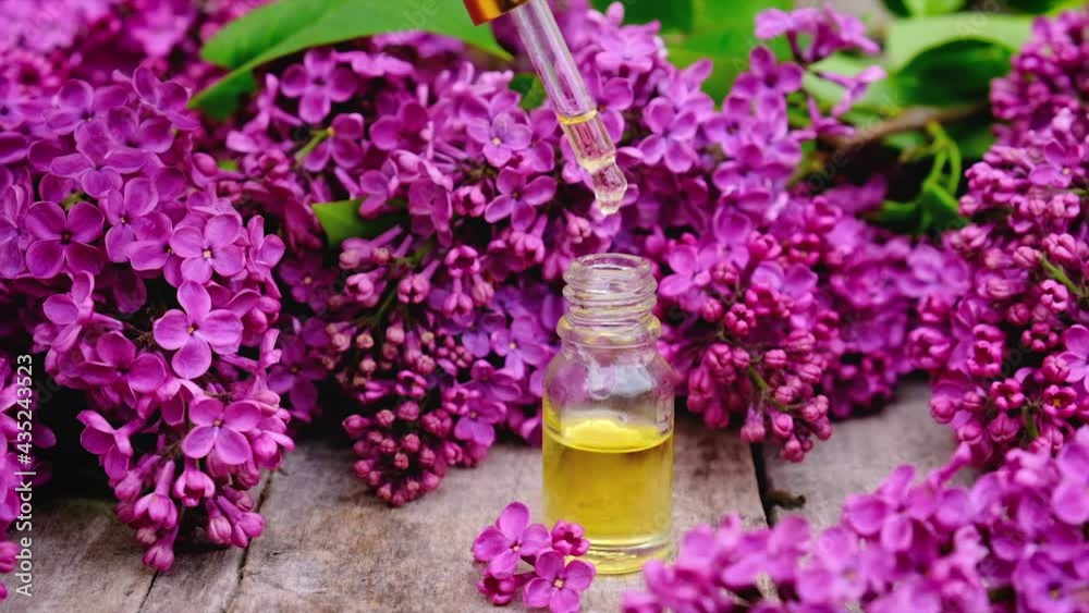 Lilac essential oil and extract in a small bottle. Selective focus. Lilac essential oil and extract in a small bottle. Selective focus.