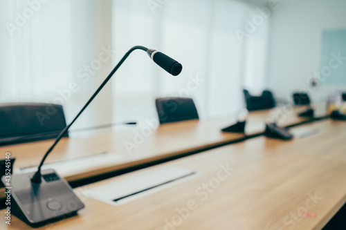 Conference microphone on wooden meeting table, a profressional eqiupment for speaker who present, speech for comunicate to audience for seminar in board room. Business concept with copy space