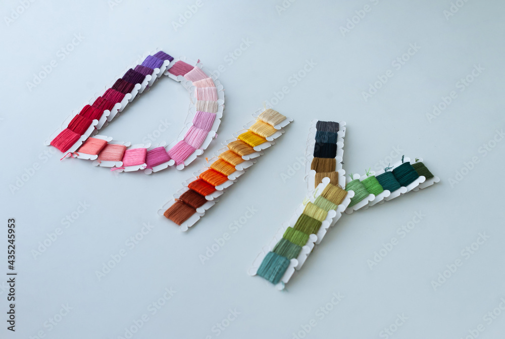 Word DIY world made of colorful bobbins, treads. Do it yourself concept. Sewing, hobby