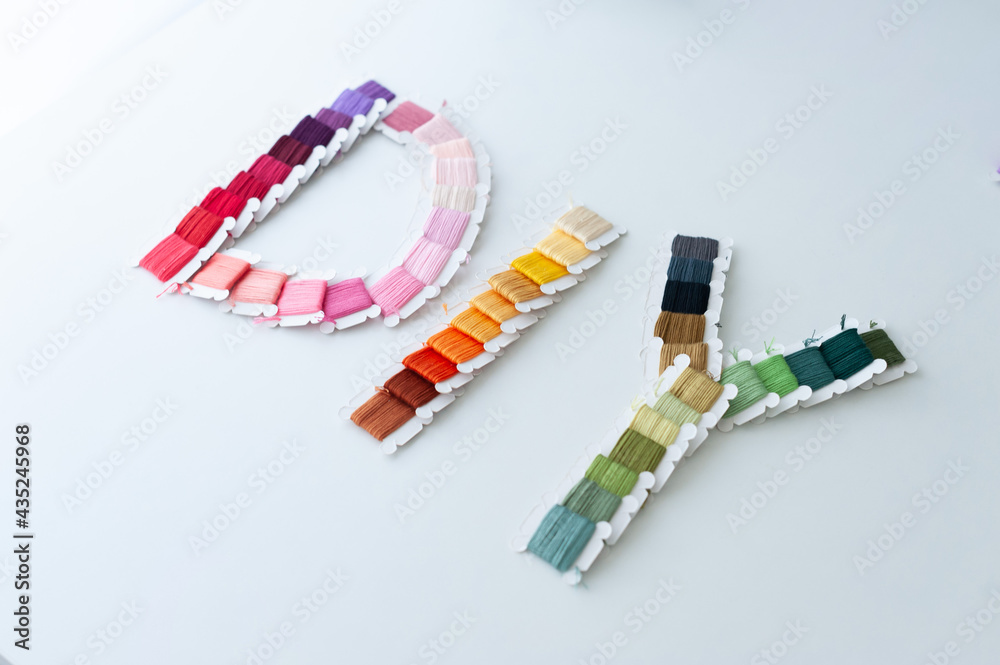 Word DIY world made of colorful bobbins, treads. Do it yourself concept. Sewing, hobby