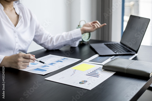Fototapeta Naklejka Na Ścianę i Meble -  A businesswoman pointing at a laptop screen that opens the company's annual financial summary is examining the document together with the head of the finance department that made it. Financial concept