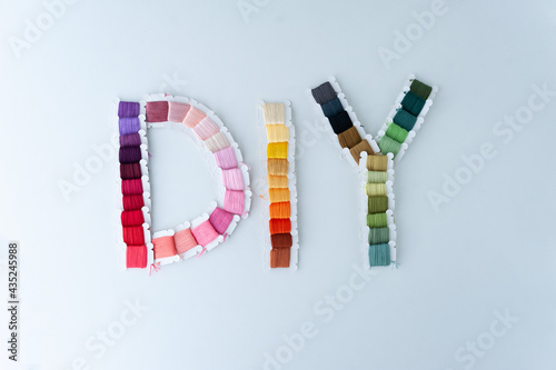 Obraz na płótnie Word DIY world made of colorful bobbins, treads. Do it yourself concept. Sewing, hobby w salonie
