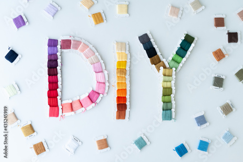 Word DIY world made of colorful bobbins, treads. Do it yourself concept. Sewing, hobby