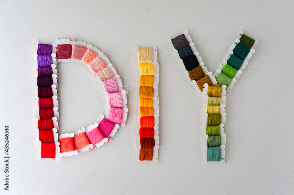 Word DIY world made of colorful bobbins, treads. Do it yourself concept. Sewing, hobby