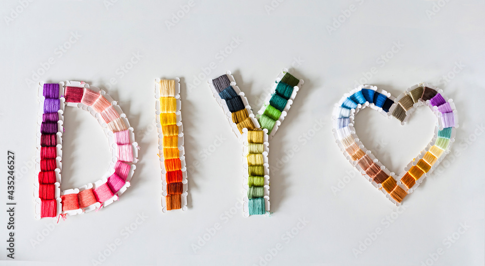 Word DIY world made of colorful bobbins, treads. Do it yourself concept. Sewing, hobby