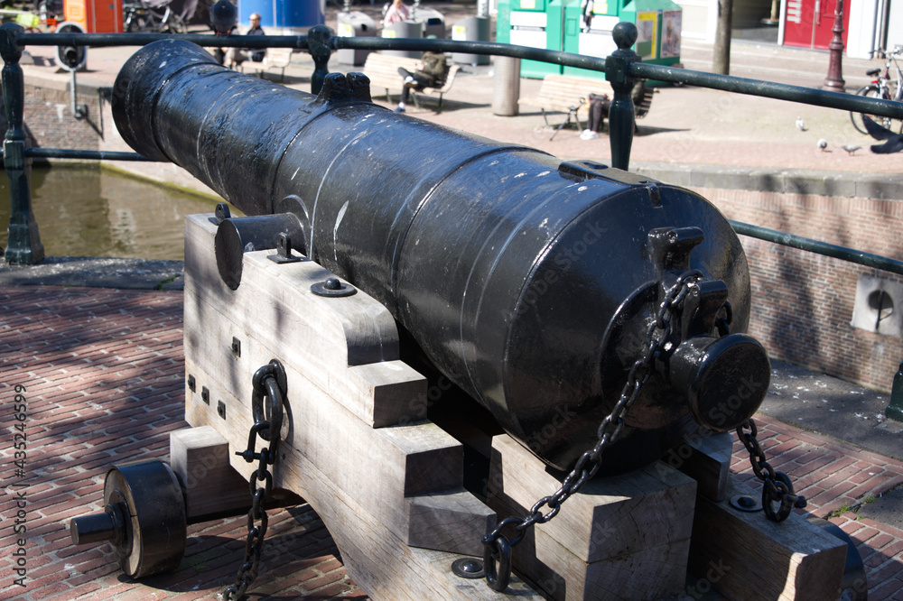 A cannon looking down a canal in downtown Amsterdam.