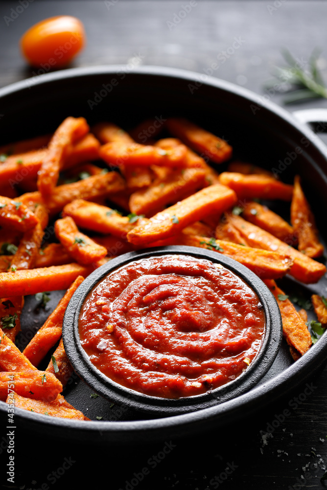 Close up of tomato sauce served with sweet potato fries on a cast iron dish Close up of tomato sauce served with sweet potato fries on a cast iron dish