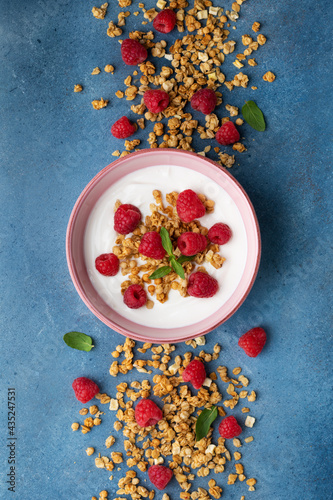 Greek yogurt with raspberries and granola. Top view flat lay. Healthy breakfast.