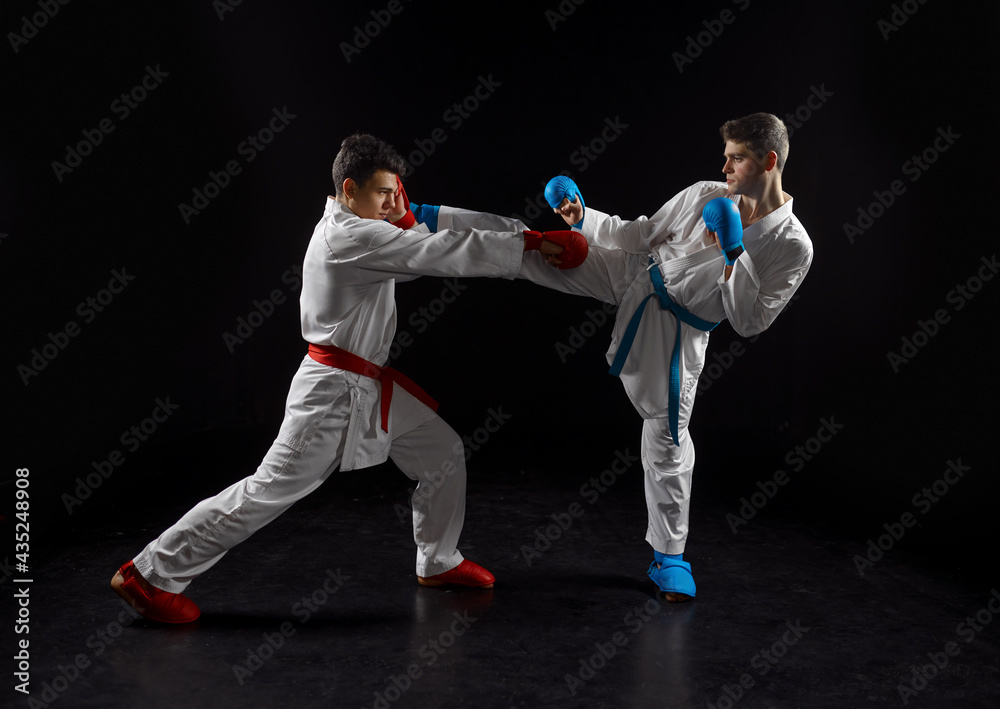 Two karatekas in white kimono and gloves, strike Two karatekas in white kimono and gloves, strike