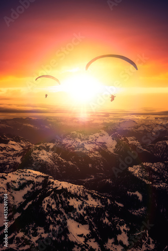Adventure Composite Image of Paraglider Flying up high in the Rocky Mountains. Sunny Sunset Sky. Aerial Background from British Columbia  Canada. Extreme Sport Concept. Panorama