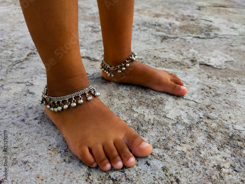 close shot of anklet chain legs isolated on rough background photo