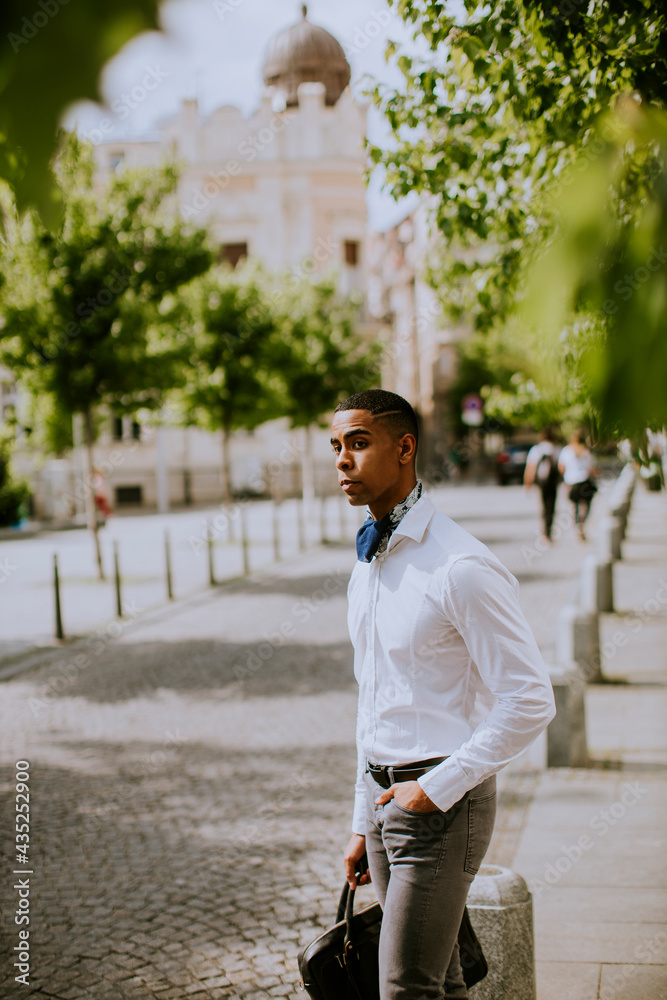 Young African American businessman waitng a taxi on a street