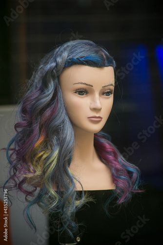 Closeup of head of mannequin with colorful hairs in a hairdresser showroom