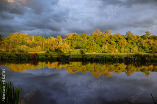 Stormy skies as the sun sets over the River Wey and meadows in Godalming  Surrey  UK