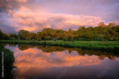 Pink skies as the sun sets over the River Wey and meadows in Godalming, Surrey, UK