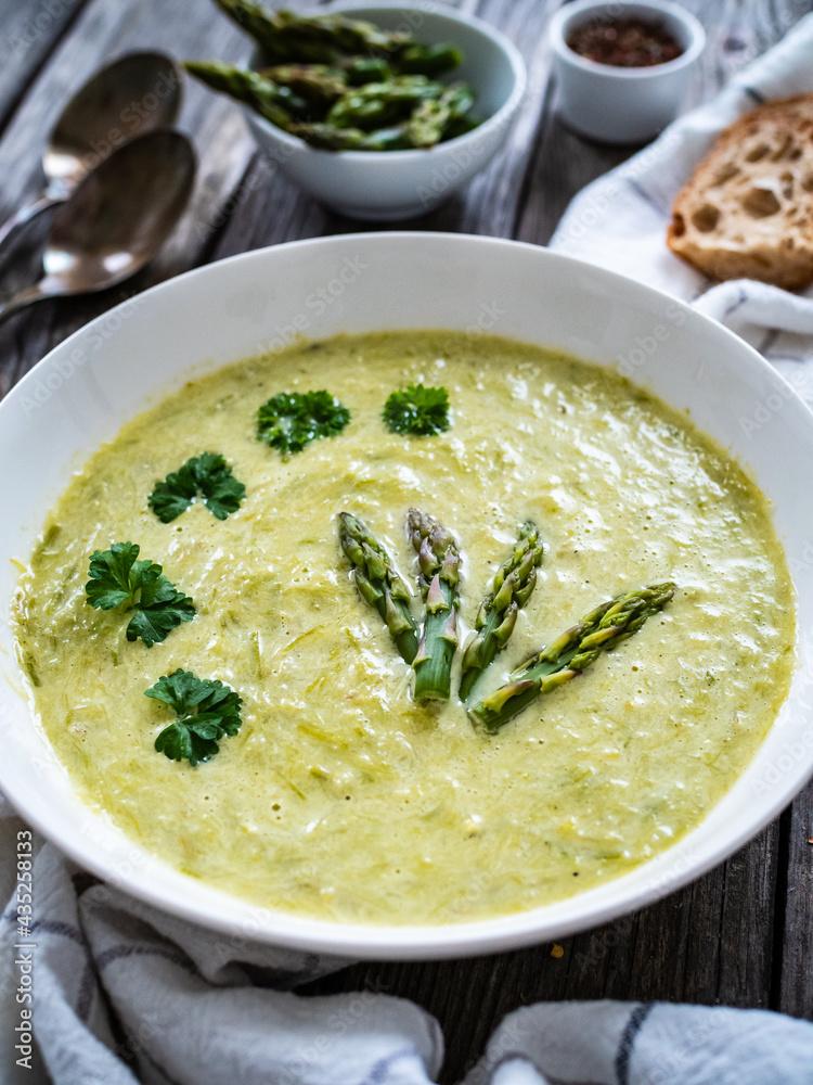 Cream asparagus soup on wooden table
