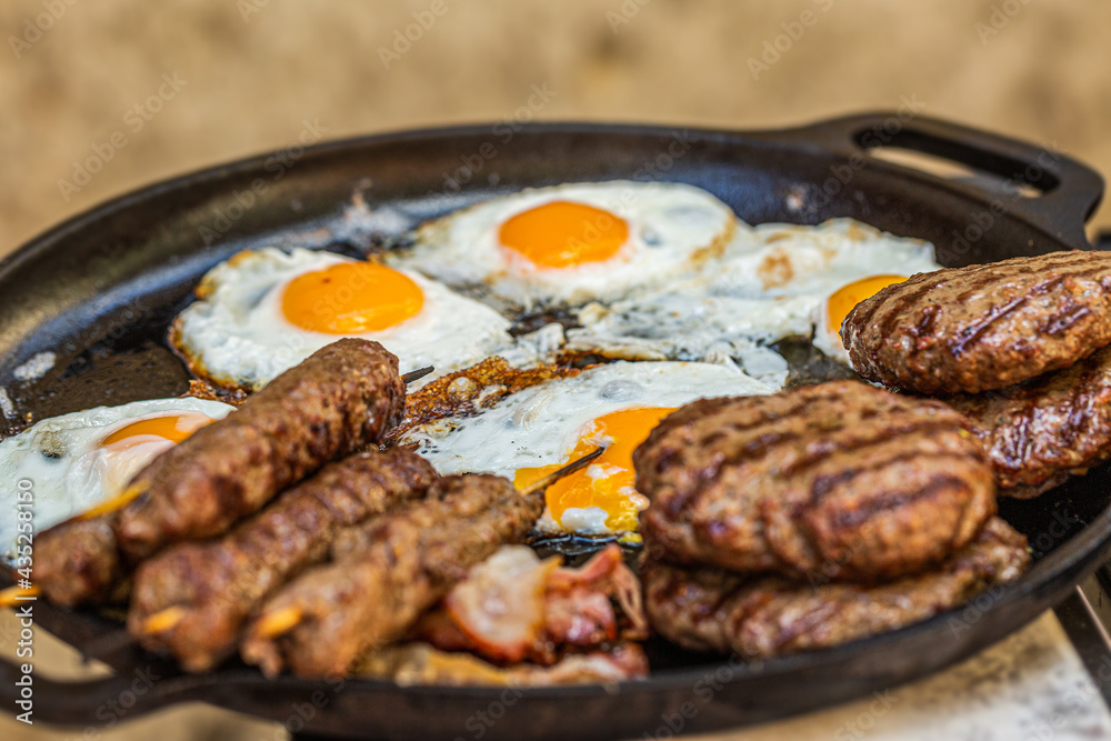 Prepared meat cutlet and fried egg for burger on pan, closeup Prepared meat cutlet and fried egg for burger on pan, closeup