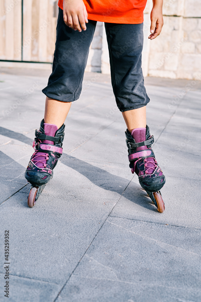 Close-up of the legs of a Child with roller skates in the park.