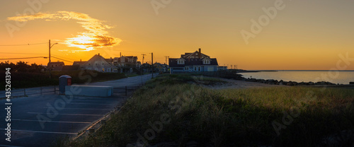 Seascape Beach at Sunrise on Cape Cod. Warm Glow of Morning Sun over the Houses on the Coastal Road.