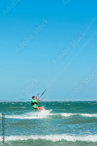 Kite surfing on the blue sea in the background of blue sky at summer time. Kiteboarding. Fun in the ocean. Extreme Sport , surfing man