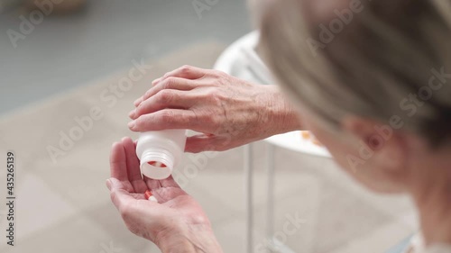 Wallpaper Mural elderly woman taking out capsules with medication. Torontodigital.ca